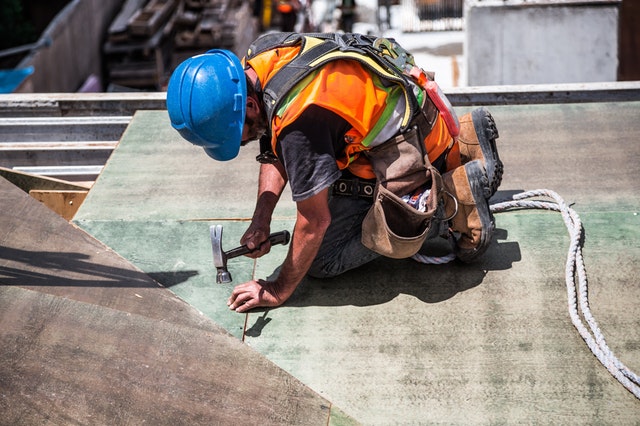 man-wearing-blue-hard-hat-using-hammer-544966